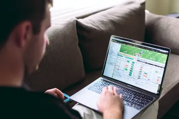 A cheerful woman in traditional clothing using her smartphone during a festive moment, showing how easily the 777JAYA app fits into everyday life.